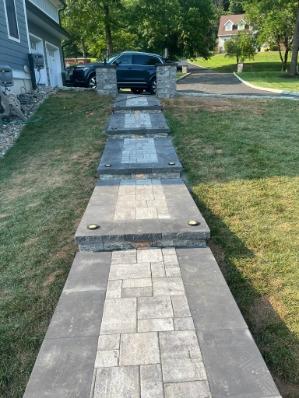 Long paver walkway set through a residential landscape